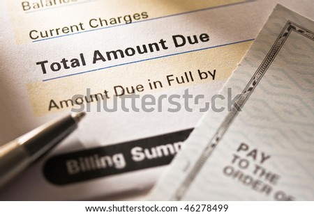 Close up of a credit card statement with personal check on top.