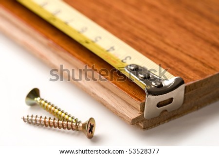 Screws, tape measure and wook board.  Concept of construction or carpentry industry.