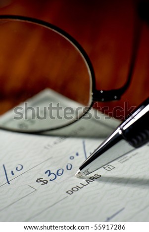 Close up of someone writing a check to pay the bill.