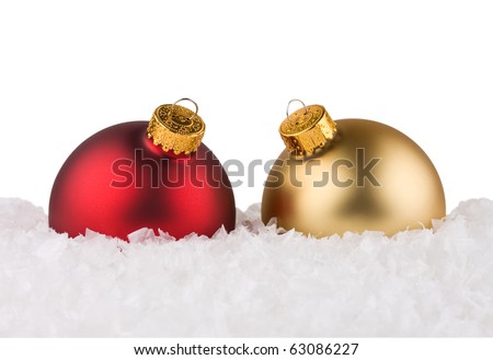 Red and gold Christmas balls sitting on snow.