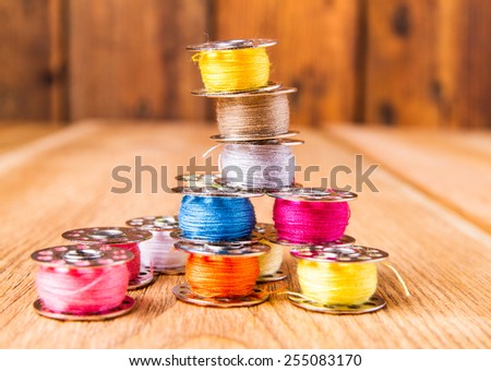 spool of thread for sewing on a wooden table