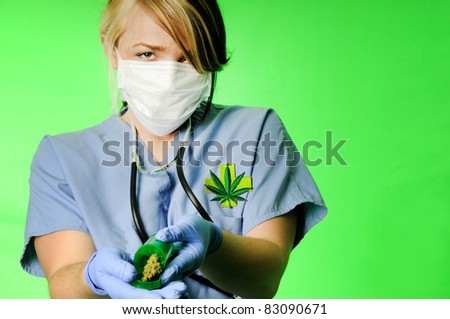 Image of a healthcare professional wearing surgical scrubs, stethoscope and mask holding a prescription bottle with marijuana inside on a chroma key background