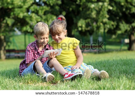 boy and little girl play with tablet pc