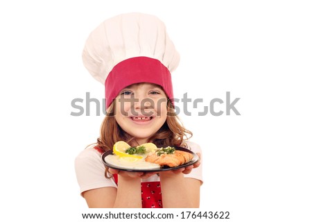 happy little girl cook with salmon fish portion