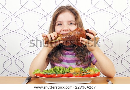 hungry little girl eating big turkey drumstick