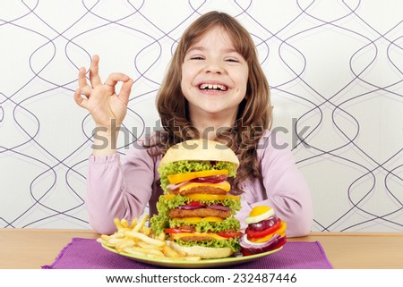 happy little girl with big hamburger and ok hand sign