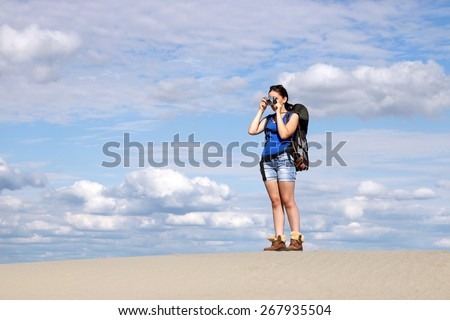 beautiful girl with camera hiking in desert