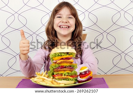 happy little girl with big hamburger and thumb up