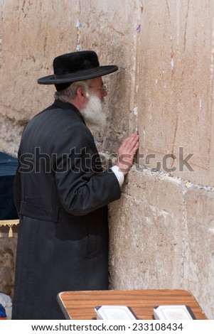 Jerusalem, Israel - March 14, 2006: Praying men at the Wailing Wall. A man dressed in a traditional Jewish coat and black hat. Wailing Wall or Kotel is located in the Old City of Jerusalem .
