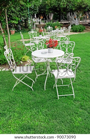 White garden furniture in beautiful garden. Vintage garden outdoor.