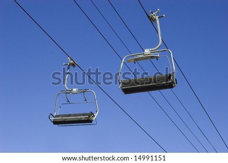 empty chairlifts on a blue sky background