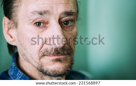 Portrait Of Serious Sad Old Adult Expressive Man With Beard Looking At Camera On Green Wall Background