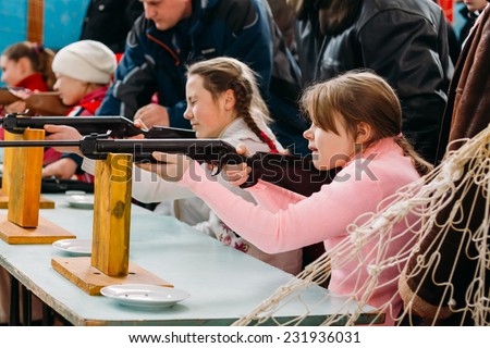 GOMEL, BELARUS - JANUARY 1, 2011: Unrecognizable Belarusian secondary school pupils girls shooting an air rifle at a school sports competition \