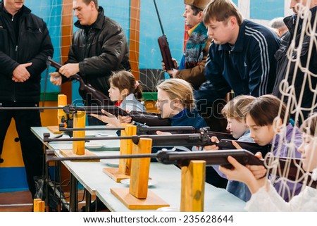 GOMEL, BELARUS - JANUARY 1, 2011: Unrecognizable Belarusian secondary school pupils girls shooting an air rifle at a school sports competition \