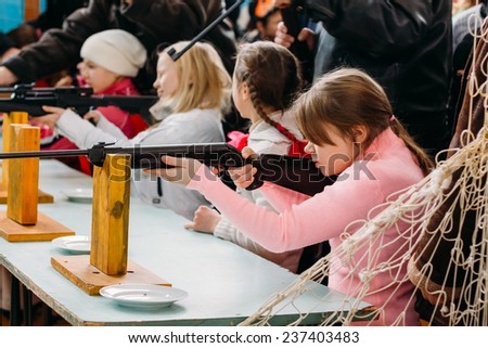 GOMEL, BELARUS - JANUARY 1, 2011: Unrecognizable Belarusian secondary school pupils girl shooting an air rifle at a school sports competition \