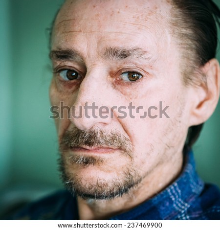 Portrait Of Serious Sad Old Adult Expressive Man With Beard Looking At Camera On Green Wall Background