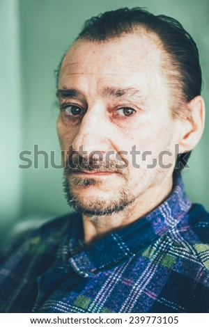 Portrait Of Serious Sad Old Adult Expressive Man With Beard Looking At Camera On Green Wall Background. Toned Photo