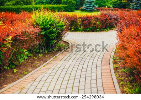 Stone Pathway Walkway Lane Path With Green Trees And Bushes In Garden. Beautiful Alley In Park. Beautiful Summer Park. Landscaping. Garden Design