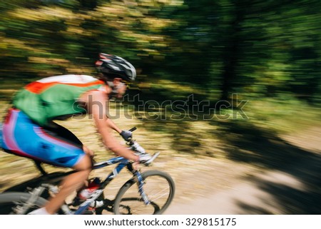 Abstract motions blur background - mountain Bike cyclist riding track at sunny day, healthy lifestyle active athlete doing sport.