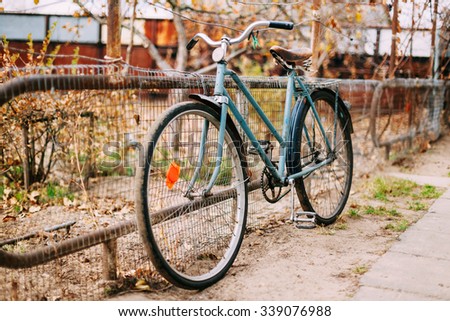 Parked vintage old bicycle bike in courtyard. Autumn season