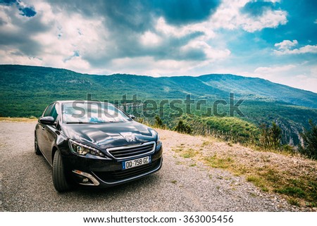Verdon, France - June 29, 2015: Black colour Peugeot 308 5-door car on background of French mountain nature landscape. The Peugeot 308 is a small family car produced by French car manufacturer Peugeot