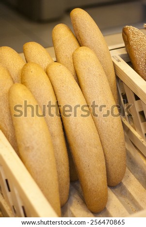 Fresh bread in basket in bakery on wooden background