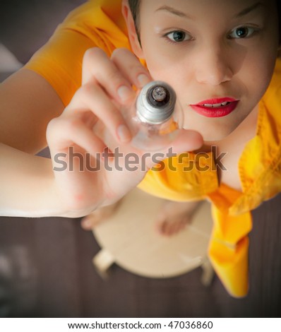young woman, stretching hand up with light bulb