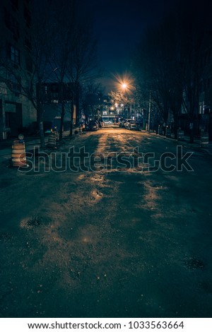 Dark empty and scary urban city street\
road with alleys under construction at night