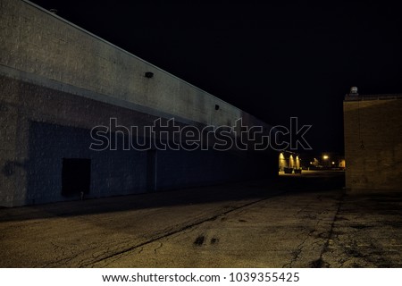 Dark industrial urban city alley at night with vintage warehouses