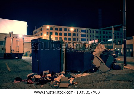 Dark industrial urban city street corner with trash and garbage dumpsters at night
