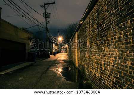Vintage brick wall in a dark, gritty and wet Chicago alley at night after rain.