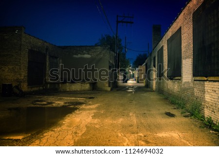 Dark, gritty and wet industrial city alley at night after rain