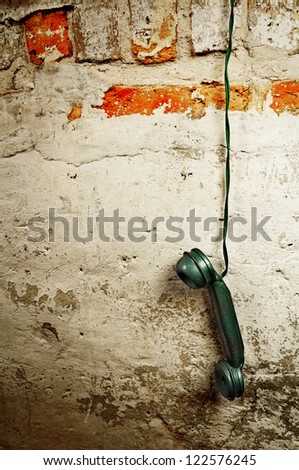 Retro Phone Cord - Vintage Telephone Handset Receiver hanging by the Cord down a Brick Wall