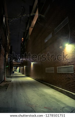 Dark and scary urban city alley with a railway bridge at night in Chicago