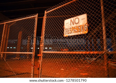 Dark and scary abandoned area with a fence under a highway city bridge at night in Chicago