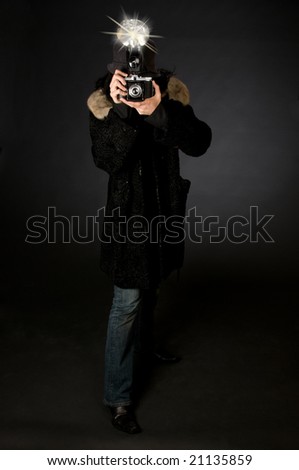 Retro style female photographer with vintage camera and flash