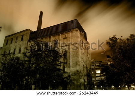 Old urban industrial building with dramatic night sky and clouds