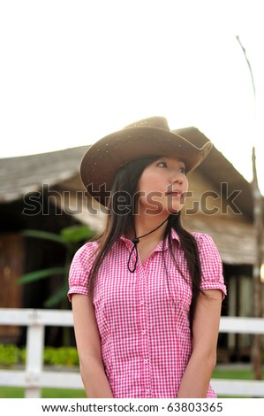 cowgirl waiting in front of country wooden house