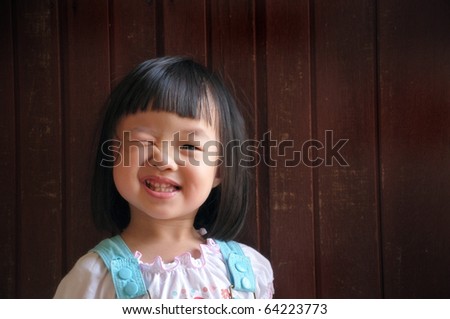 happy cute young girl wink with wooden background