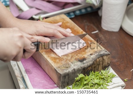 hand with knife cutting food ingredient