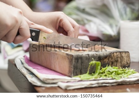 hand with knife cutting food ingredient