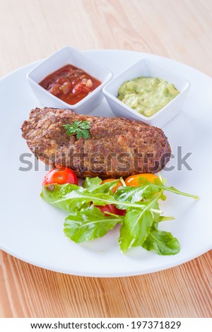 Fusion style fried pork and bread with red and green sauce.