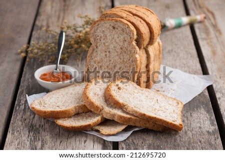 Sliced whole wheat bread with Thai tea cream on table.