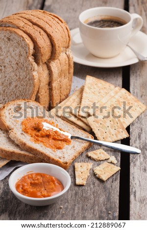 Sliced whole wheat bread with crackers, coffee and Thai tea cream on table.