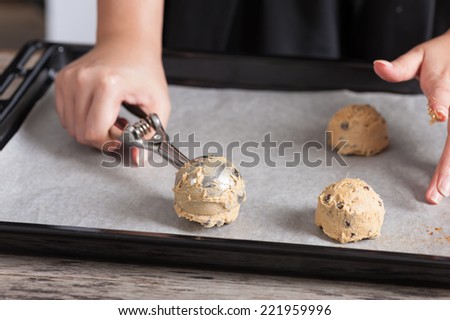 Putting mixed cookie ingredients into tray