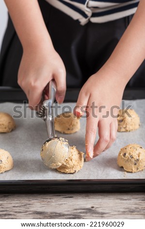 Putting mixed cookie ingredients into tray