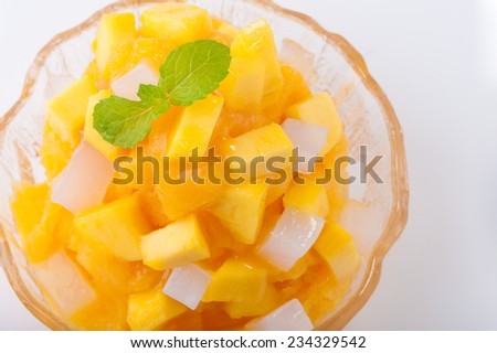 Mango flavoured shave ice with pieces of mango and coconut jelly.