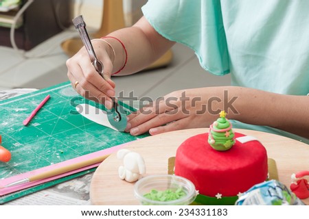 The making of christmas fondant cake in kitchen.
