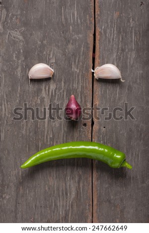 Shallots (red onion), garlics and green chilli set up on wood table with low key scene.