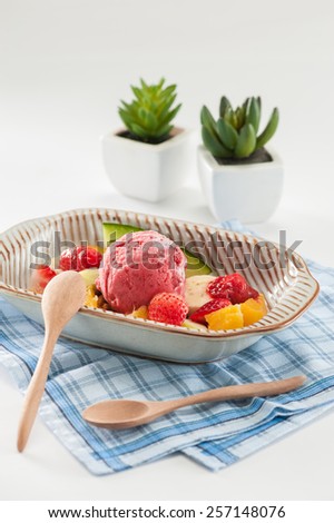 Berry ice cream scoop with mixed fruits.
